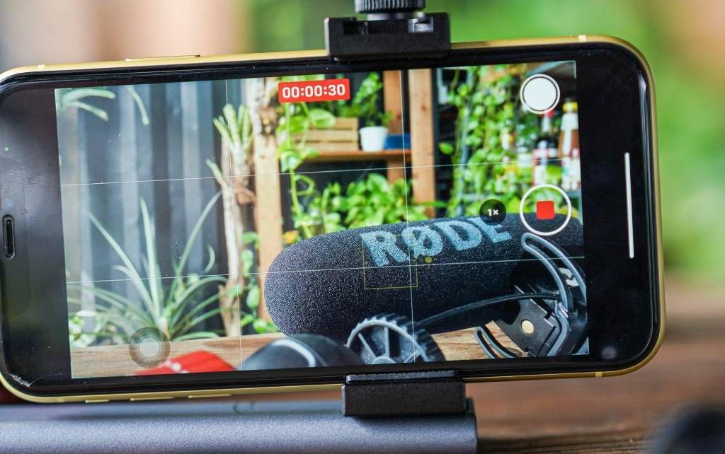 Person using Snapchat hands-free recording feature on smartphone indoors