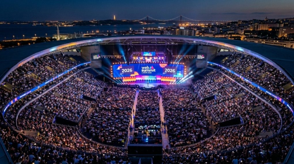 Aerial view of a packed Centre Stage audience at Web Summit Lisbon 2026, with bright lights illuminating the Altice Arena during the opening night keynote