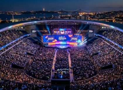 Aerial view of a packed Centre Stage audience at Web Summit Lisbon 2026, with bright lights illuminating the Altice Arena during the opening night keynote