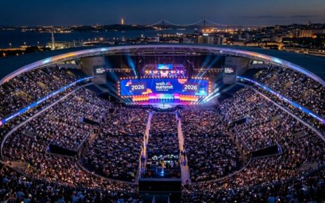Aerial view of a packed Centre Stage audience at Web Summit Lisbon 2026, with bright lights illuminating the Altice Arena during the opening night keynote